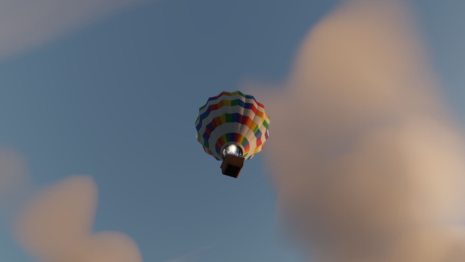 A brightly striped balloon seen from below, high against a blue sky with cloud